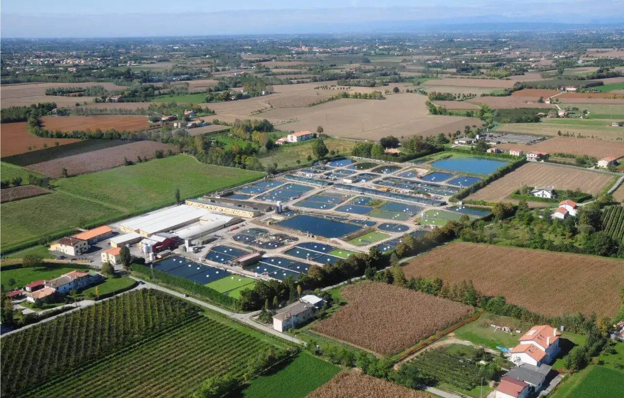 Vue aérienne d'une ferme aquacole produisant de l'esturgeon beluga, avec de nombreux bassins et bâtiments.